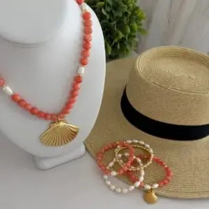 Coral colored beads called Botswana Agate with a shell focal pendant. Freshwater pearl stations