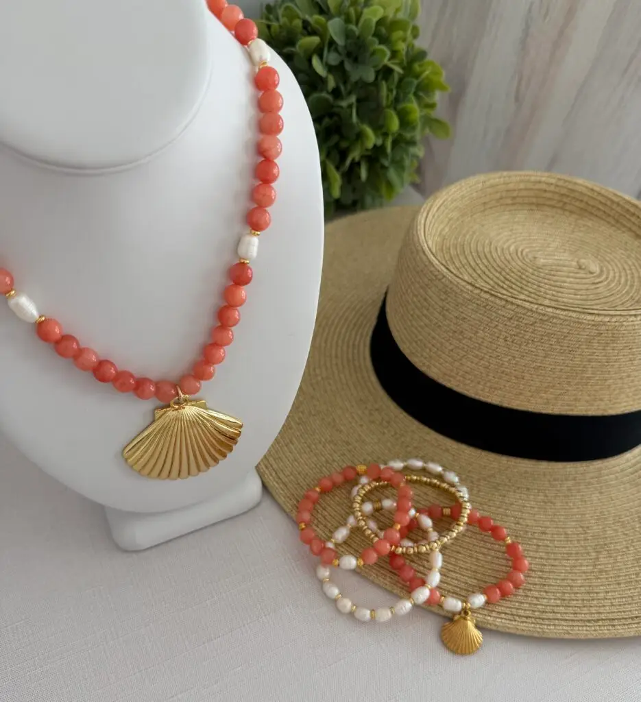 Coral colored beads called Botswana Agate with a shell focal pendant. Freshwater pearl stations