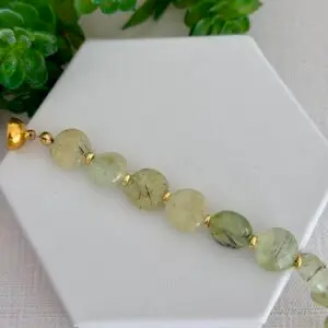 Beautiful green prehnite gemstone bracelet. Coin shape beads spaced with gold disk accent beads. The clasp is magnetic.