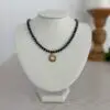 Blue lapis lazuli beads separated by gold disk spacers. 16” with a round gold and moonstone medallion in the center. The clasp is a lobster style closure