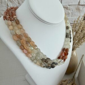 Four strands of three colors of moonstone beads layered as one necklace. The colors are rust/peach ivory and brown. The necklace is approxamately 18” long and has a lobster claw clasp.