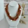 6 layers of rose quartz gemstones in chip cut beads. The necklace also has baroque pearls scattered throughout. The clasp is in silver and is an oversized lobster claw closure. It is approxamately 18” in length