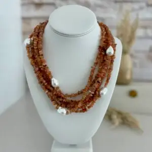 6 layers of rose quartz gemstones in chip cut beads. The necklace also has baroque pearls scattered throughout. The clasp is in silver and is an oversized lobster claw closure. It is approxamately 18” in length